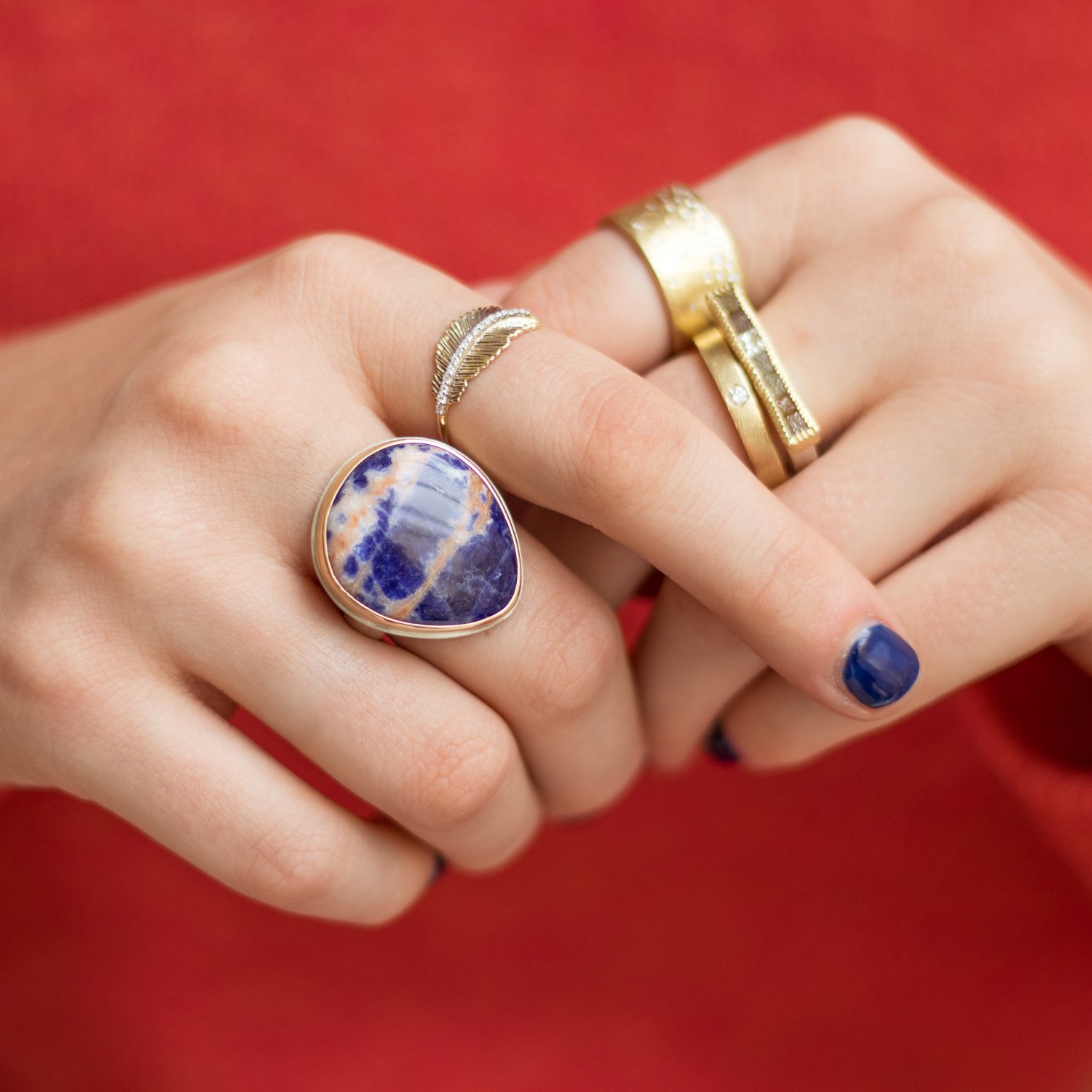 Sodalite right with 14K yellow gold bezel and sterling silver band by jewelry designer Jamie Joseph, 14K yellow gold diamond arrow feather ring by jewelry designer Kismet by Milka, 18K yellow gold wide diamond scatter band by jewelry designer Todd Reed