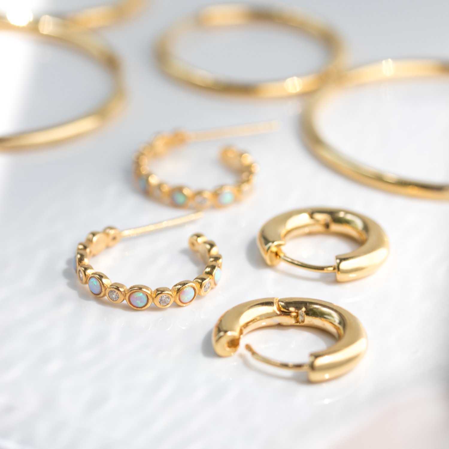 Gold hoop earrings by Tai