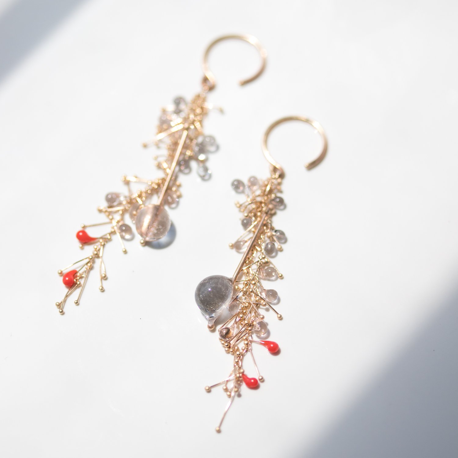 Orange and beige fiber optic earrings in gold and glass by Jess Panza