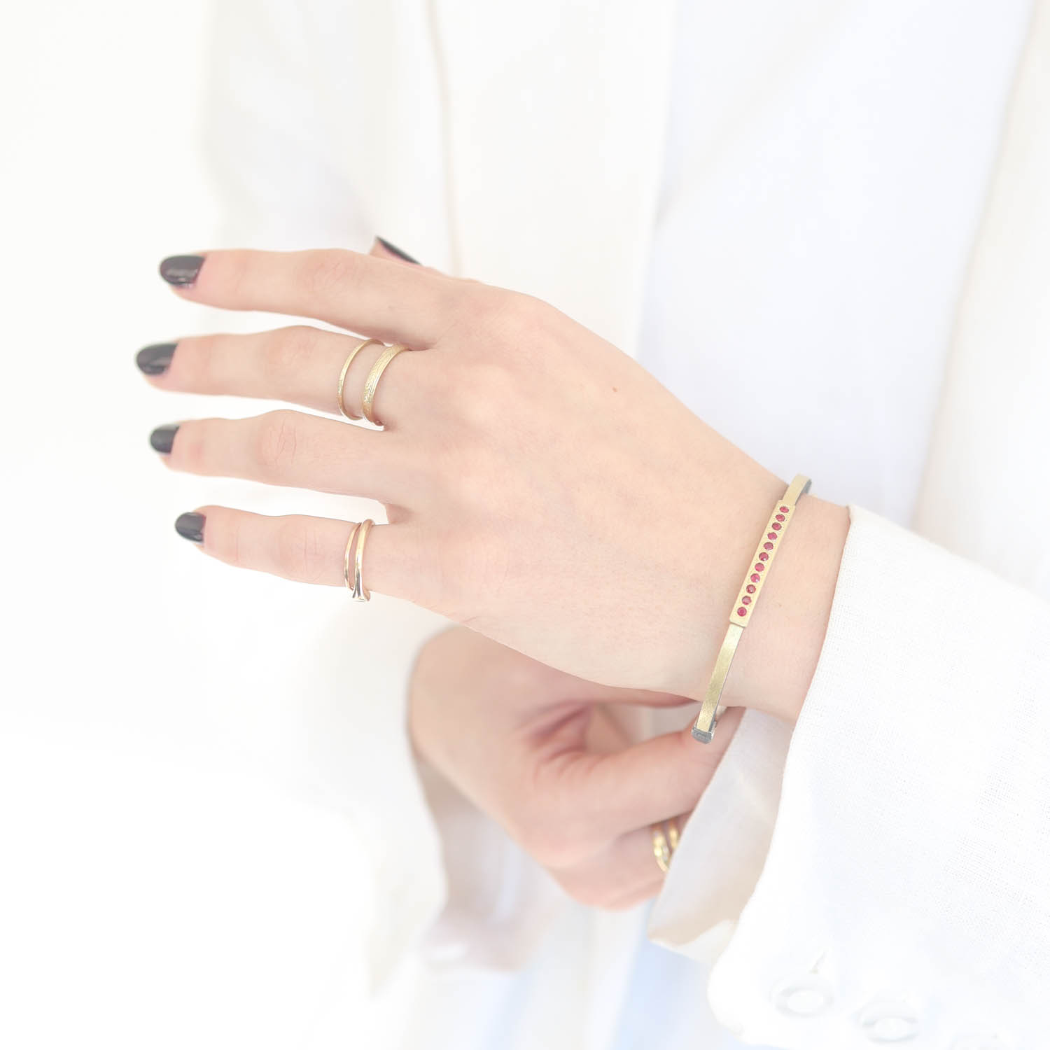 Rene Escobar: 2.5MM. SS hinged bangle featuring an 18k YG push button style clasp and 18k YG top sheet set with 0.40CT RUBY