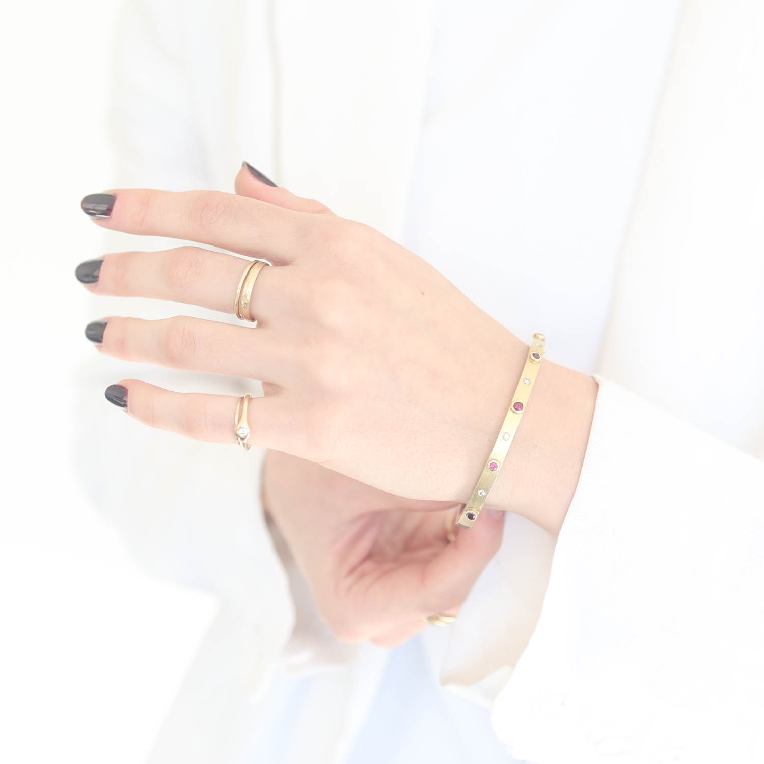 Rene Escobar Trunk Show:33 4MM. SS hinged bangle featuring an 18k YG push button style clasp and 5 18k YG bezels set 0.88CT of RU.